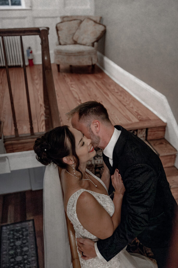 Bride and groom snuggling up on staircase railing