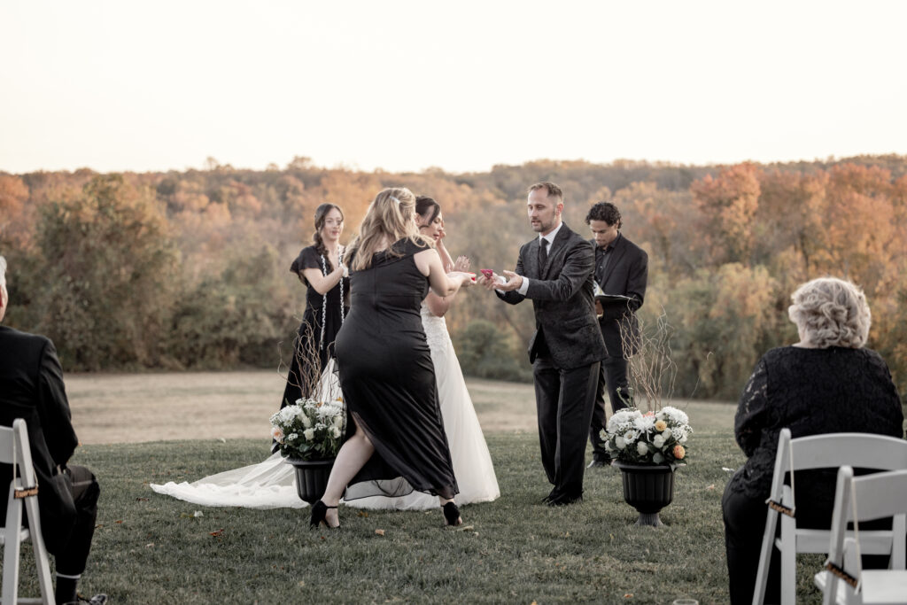 bride and groom doing scavanger hunt at their ceremony and person found the rings quickly bringing it up to the groom.