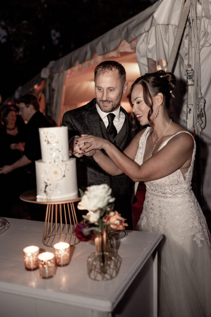 bride and groom cutting two layer cake by KNE Bakery