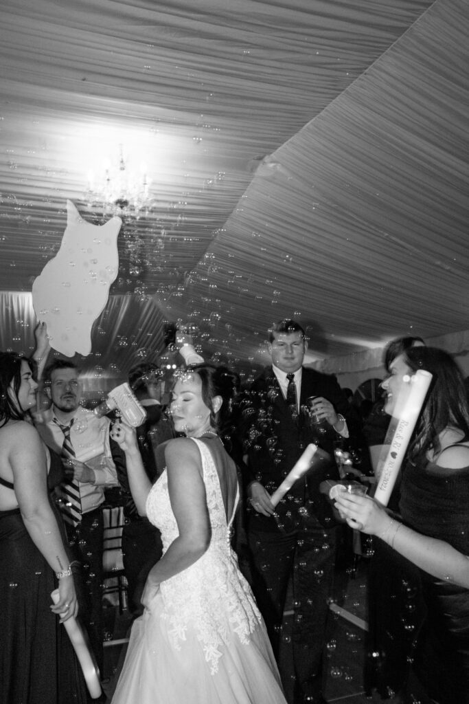 Bride dancing and using bubble gun.