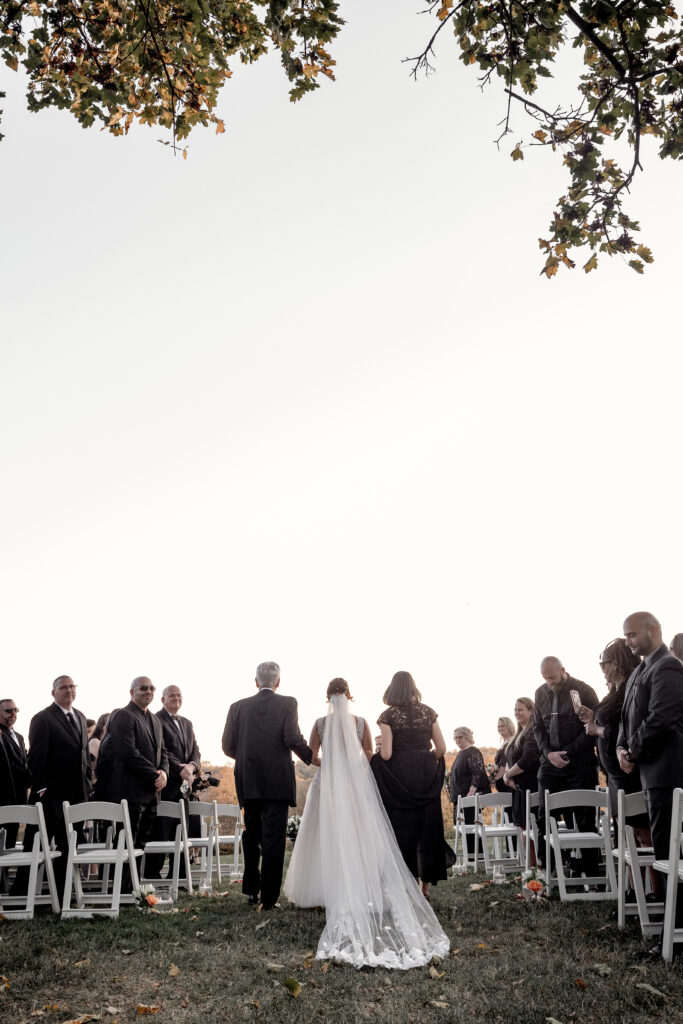 Bride walking down the aisle with both mom and dad.