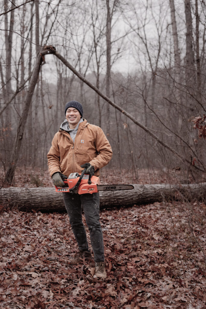 Man holding Chainsaw in forest for chopping wood.